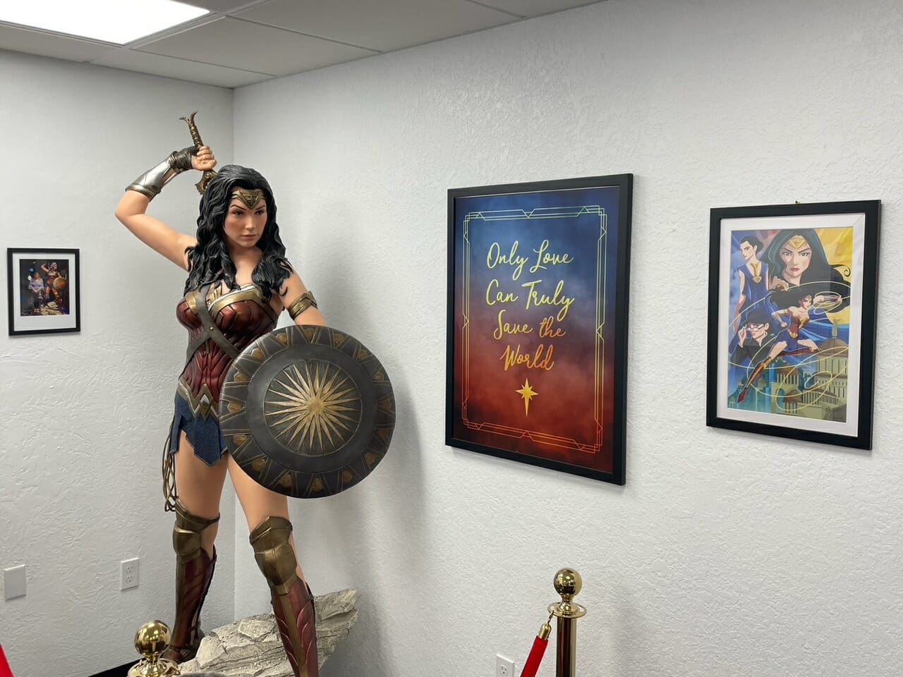 Wonder Woman statue with framed artwork
