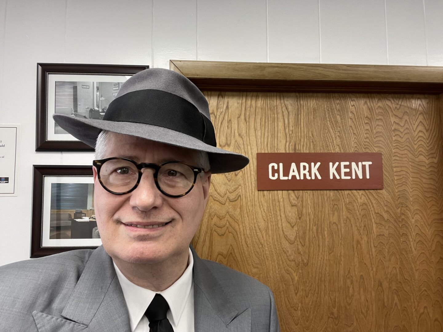 Smiling person by Clark Kent door